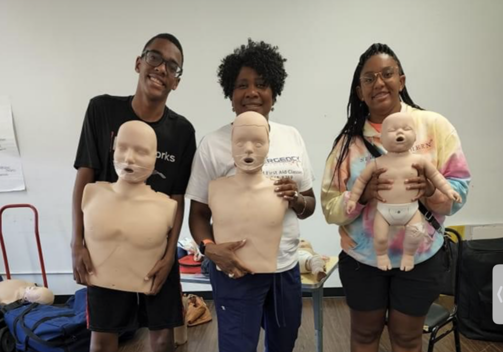 3 people holding CPR mannequins